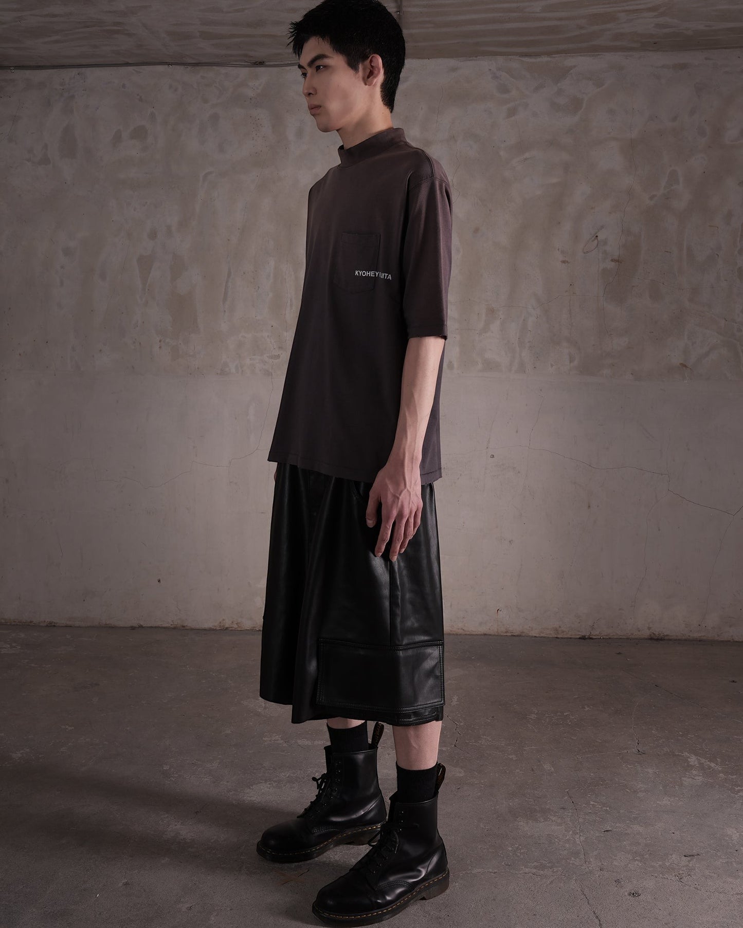KYOHEY_FUJITAのダークグレーのヘビーウォッシュドモックネックロゴTシャツを着用したモデルの横向きショット