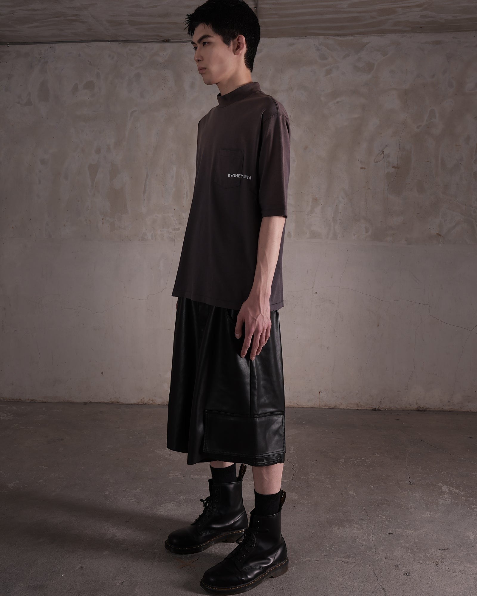 KYOHEY_FUJITAのダークグレーのヘビーウォッシュドモックネックロゴTシャツを着用したモデルの横向きショット