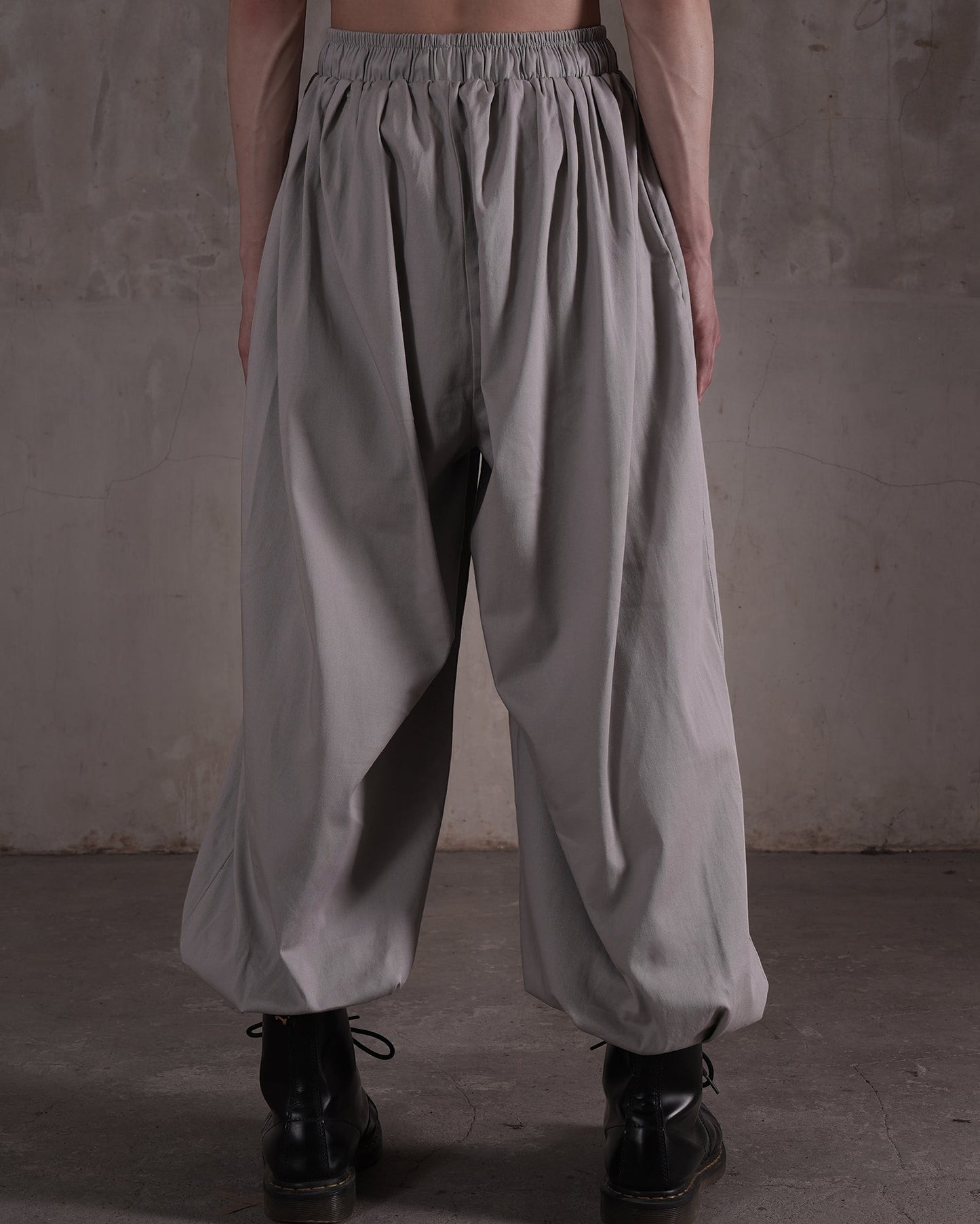 KYOHEY_FUJITAのグレーのマルチタックハーレムパンツ。ウエストゴム仕様でゆったりとしたシルエットのドレープ感あるデザイン。