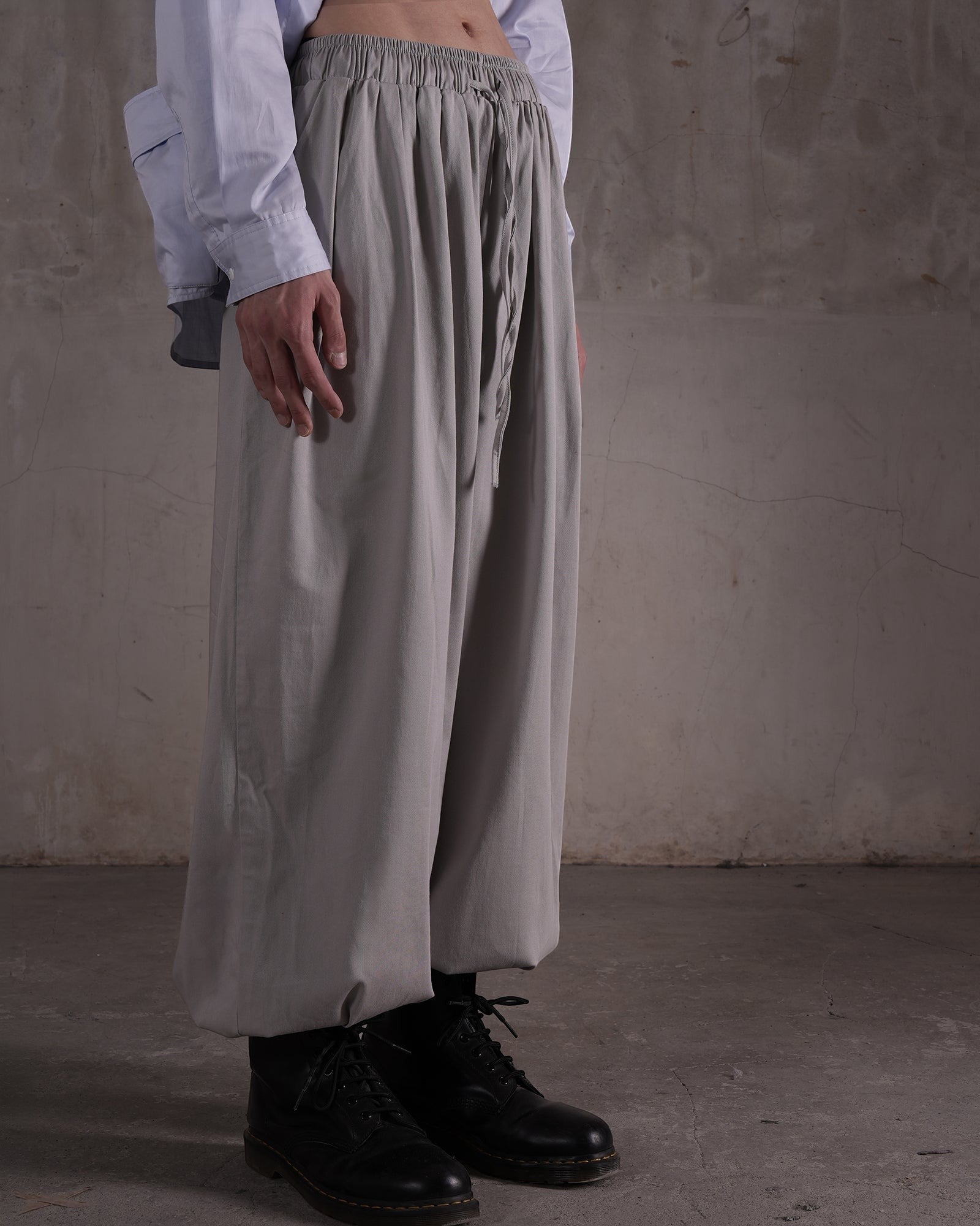 KYOHEY_FUJITAのグレーのマルチタックハーレムパンツ。ゆったりとしたシルエットでウエストはドローストリング仕様。