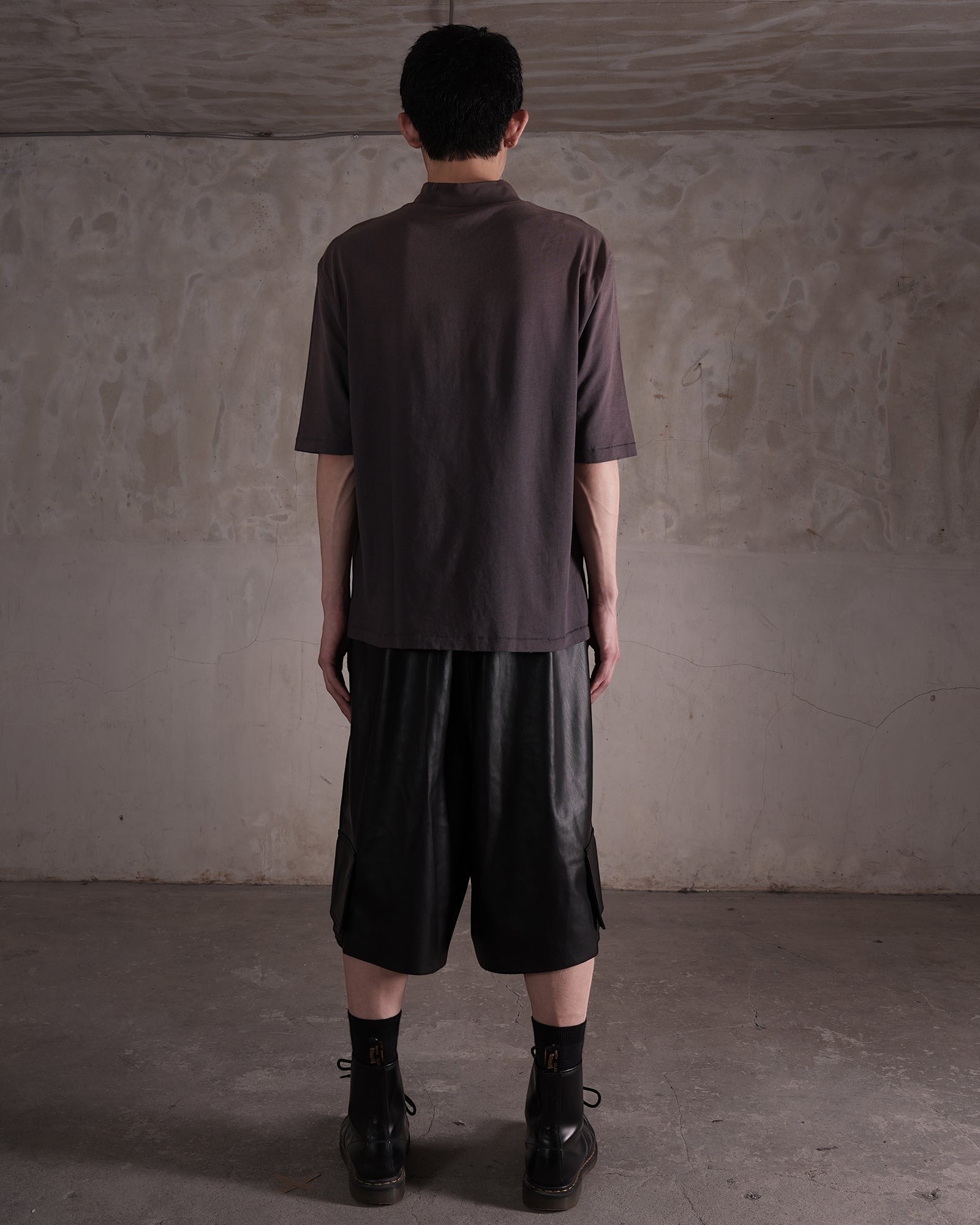 KYOHEY_FUJITAのヘビーウォッシュ加工モックネックTシャツを着用した男性の背面ショット