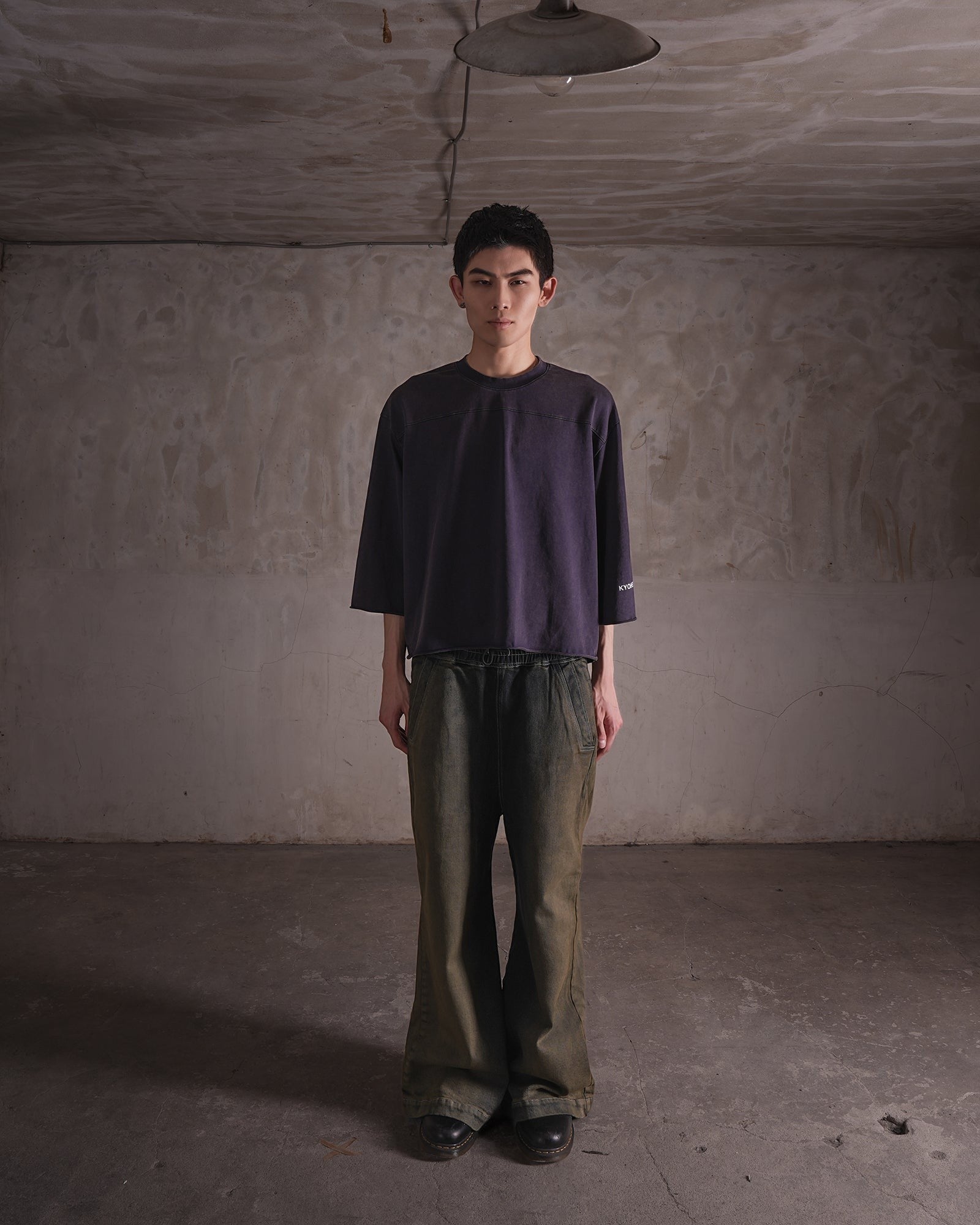 KYOHEY_FUJITAのヴィンテージ加工されたダークグレーのクロップド丈ボックスロゴTシャツを着用した男性モデル